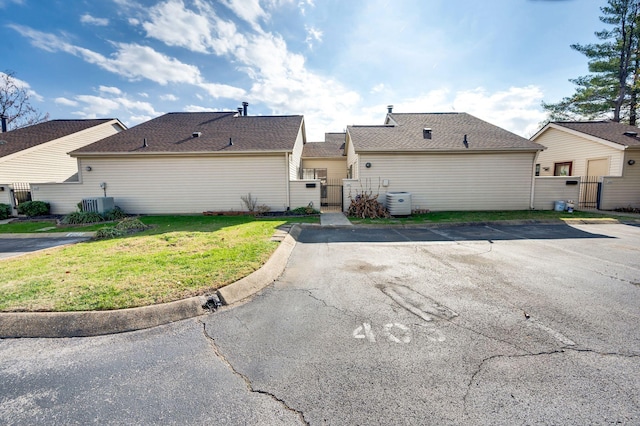 exterior space with cooling unit and a lawn