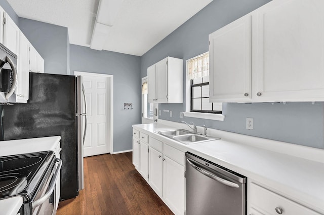 kitchen featuring stainless steel appliances, white cabinetry, dark wood-type flooring, and sink