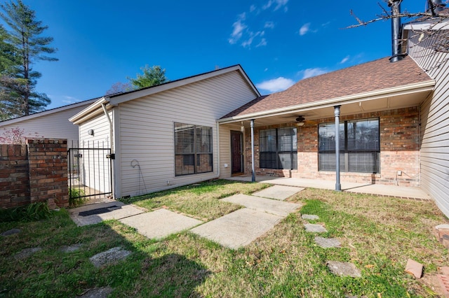 rear view of house with a yard and ceiling fan