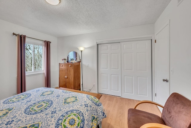 bedroom with wood-type flooring, a textured ceiling, and a closet