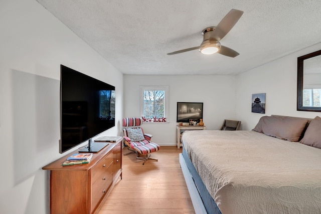 bedroom featuring a textured ceiling, light hardwood / wood-style floors, and ceiling fan