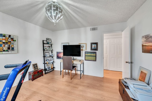 office featuring a textured ceiling and light hardwood / wood-style floors