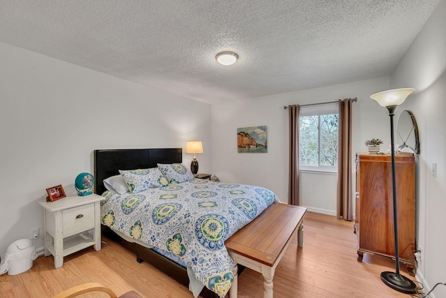 bedroom featuring light hardwood / wood-style flooring and a textured ceiling