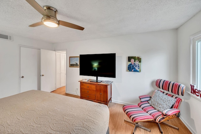 bedroom featuring ceiling fan, a textured ceiling, and light hardwood / wood-style flooring