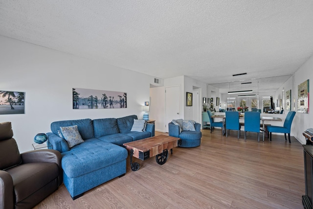 living room with wood-type flooring and a textured ceiling