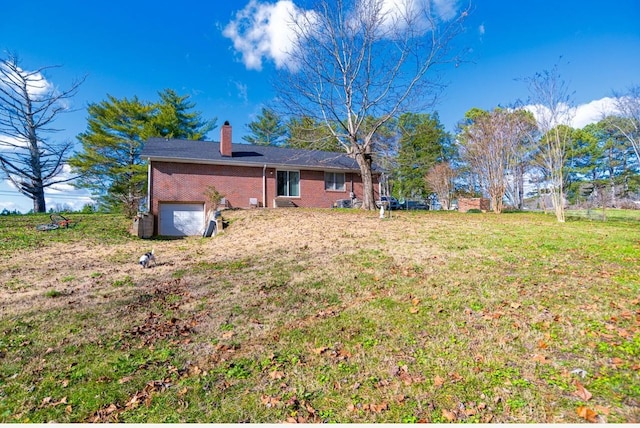 back of house featuring a yard and a garage