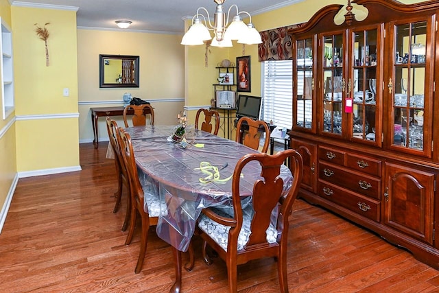 dining space with an inviting chandelier, hardwood / wood-style flooring, and ornamental molding