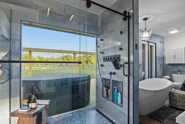 bathroom with a shower with door, a chandelier, tile walls, and toilet