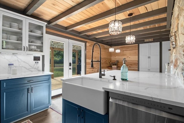 kitchen with dishwasher, decorative light fixtures, blue cabinetry, and wooden walls