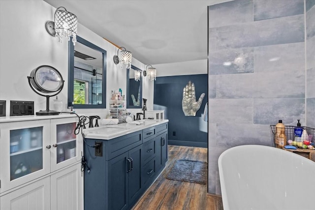 bathroom featuring a washtub, vanity, hardwood / wood-style flooring, and tile walls