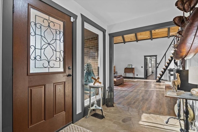 foyer entrance with beamed ceiling and light wood-type flooring