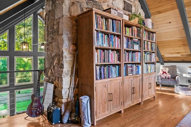 interior space featuring wood walls, wood ceiling, high vaulted ceiling, and light hardwood / wood-style flooring