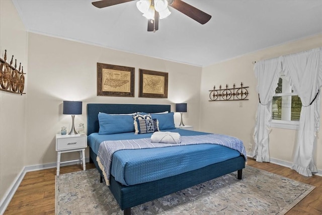 bedroom with ceiling fan, hardwood / wood-style floors, and ornamental molding