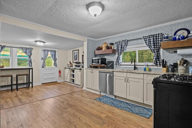 kitchen featuring stainless steel appliances, white cabinetry, plenty of natural light, and light hardwood / wood-style floors