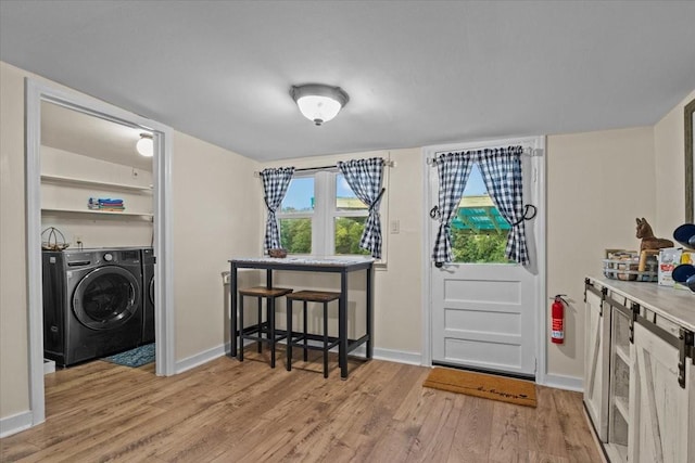 laundry area with light hardwood / wood-style flooring and washer and clothes dryer