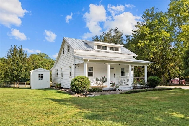 view of front facade featuring covered porch, a storage shed, and a front lawn