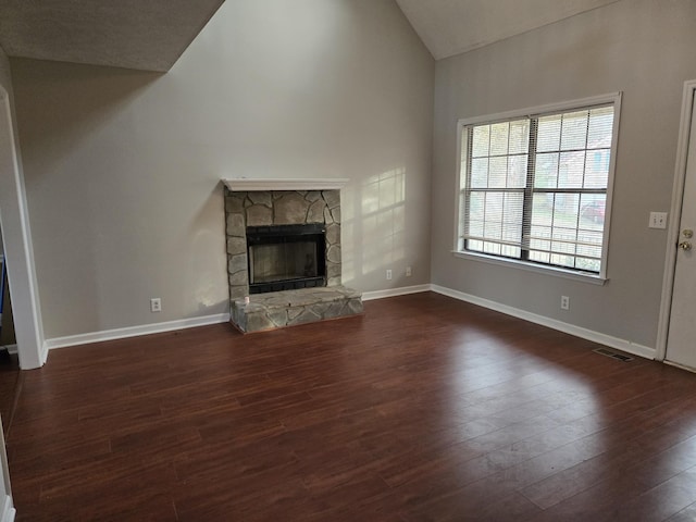 unfurnished living room with lofted ceiling, a fireplace, and dark hardwood / wood-style floors