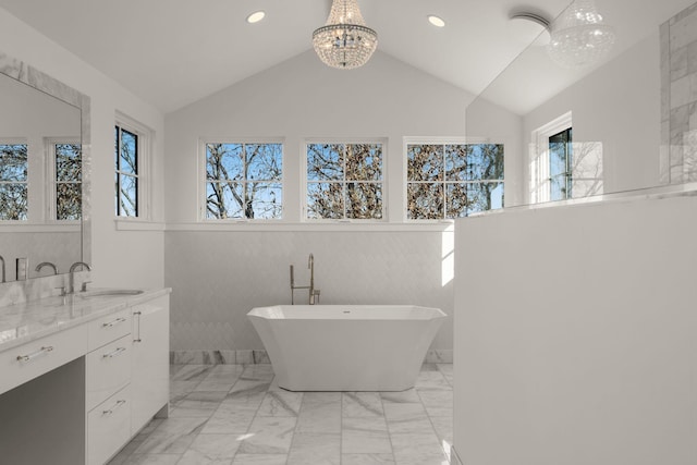 bathroom featuring a bath, vanity, a wealth of natural light, and lofted ceiling