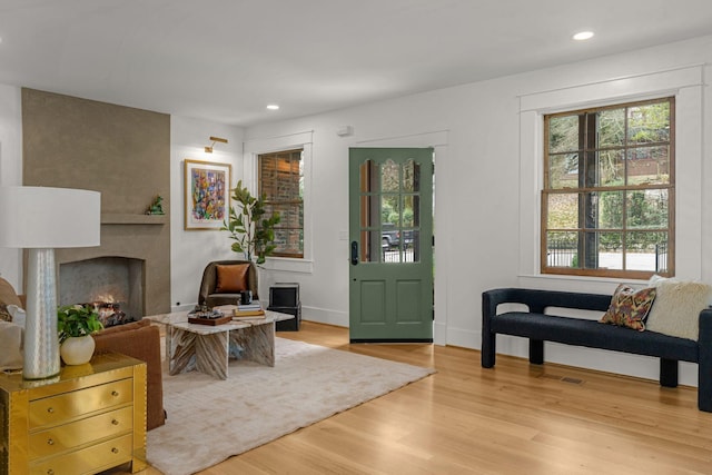 living room with a large fireplace and light wood-type flooring