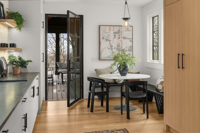 dining room with breakfast area, sink, and light hardwood / wood-style flooring