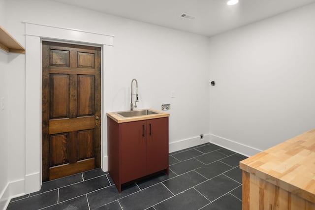 washroom featuring washer hookup, sink, hookup for an electric dryer, and dark tile patterned flooring