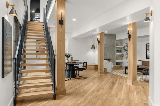 stairway featuring a large fireplace and hardwood / wood-style floors