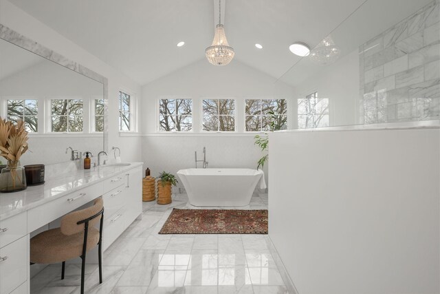 bathroom featuring vanity, lofted ceiling, a bath, and a chandelier