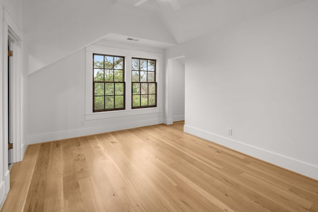 unfurnished room featuring vaulted ceiling and light hardwood / wood-style flooring