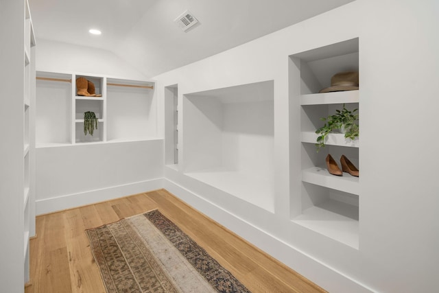 mudroom with lofted ceiling, hardwood / wood-style floors, and built in features