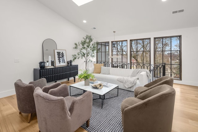 living room featuring high vaulted ceiling and light wood-type flooring