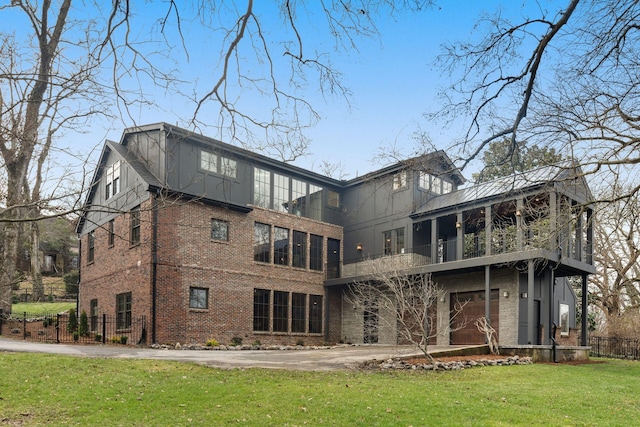 rear view of house with a garage and a lawn