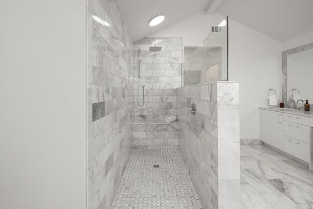 bathroom with tiled shower, vanity, and vaulted ceiling with beams