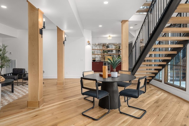 dining area with decorative columns and light wood-type flooring