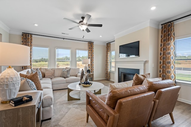 living room featuring light wood-type flooring, ceiling fan, and crown molding