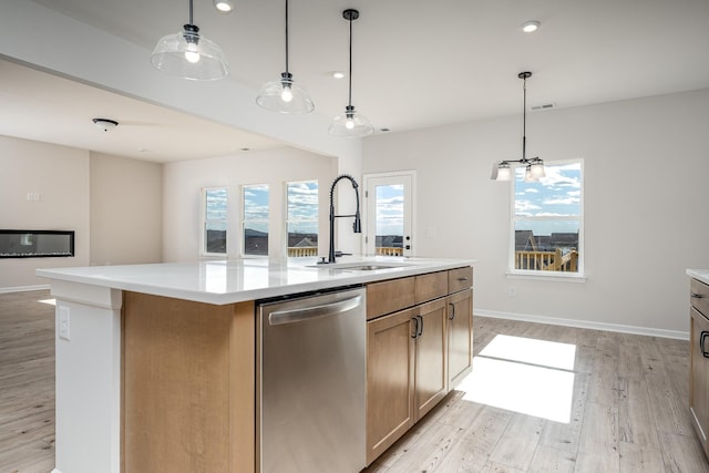 kitchen with a kitchen island with sink, sink, pendant lighting, light hardwood / wood-style flooring, and dishwasher