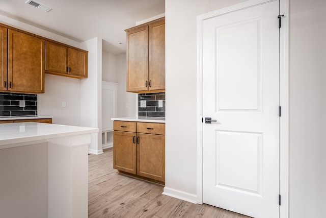 kitchen with decorative backsplash and light hardwood / wood-style floors