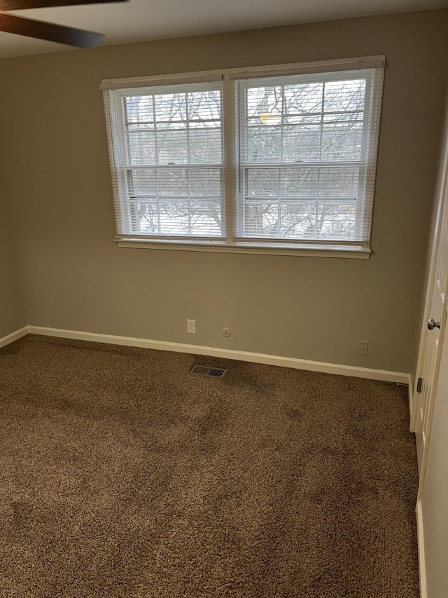 empty room featuring carpet flooring, ceiling fan, and a wealth of natural light