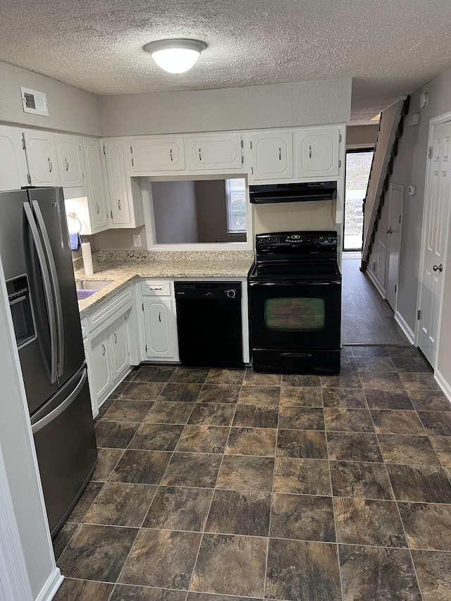 kitchen with a wealth of natural light, white cabinetry, black appliances, and a textured ceiling