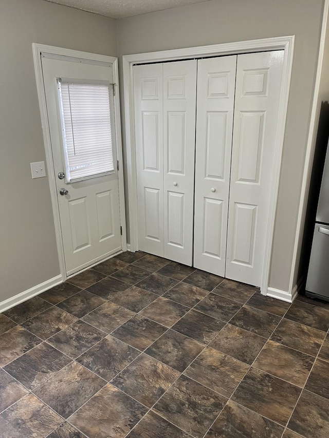 unfurnished bedroom with stainless steel fridge and a closet