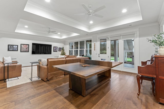 interior space featuring dark hardwood / wood-style flooring, a tray ceiling, crown molding, and ceiling fan