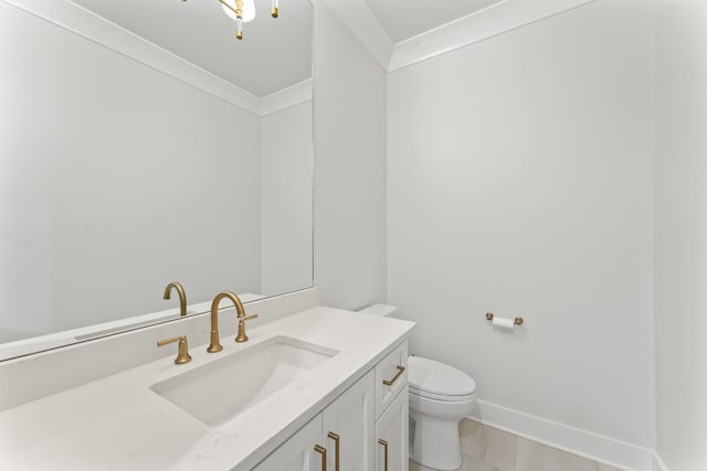 bathroom with vanity, crown molding, and toilet