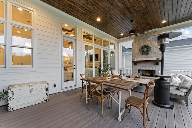 deck with a fireplace and ceiling fan