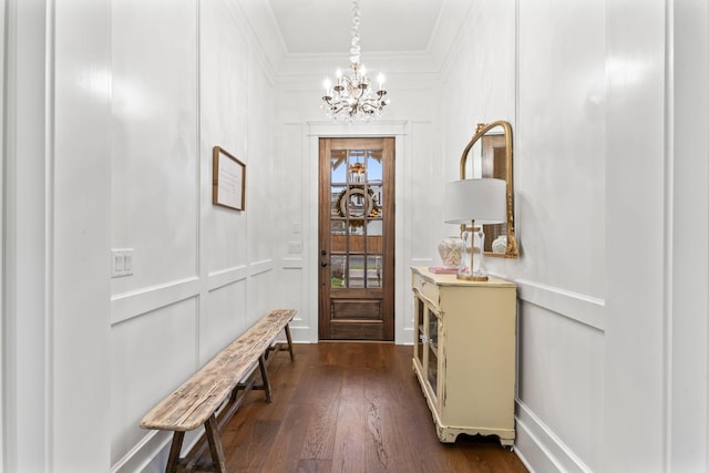 foyer entrance featuring crown molding, dark hardwood / wood-style floors, and a chandelier