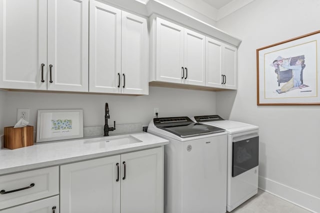 washroom with light tile patterned flooring, cabinets, sink, and washing machine and dryer