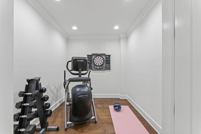 exercise area featuring ornamental molding and dark hardwood / wood-style floors