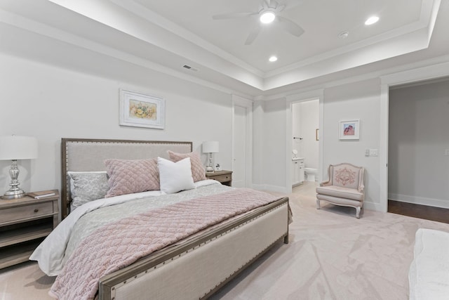 carpeted bedroom featuring crown molding, ceiling fan, ensuite bathroom, and a raised ceiling