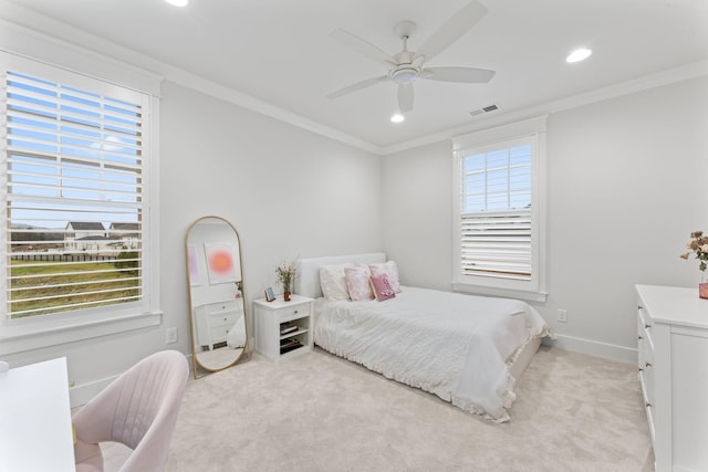 carpeted bedroom with ornamental molding and ceiling fan