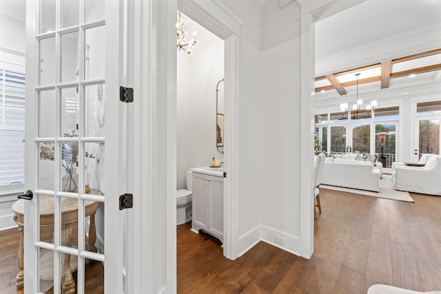 bathroom with beamed ceiling, sink, hardwood / wood-style flooring, coffered ceiling, and a notable chandelier