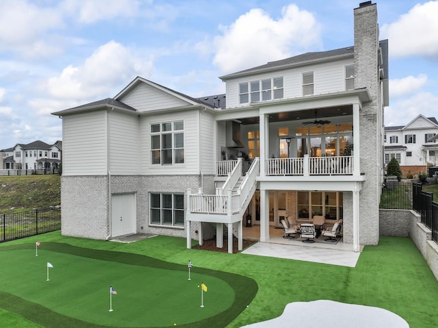 rear view of property with ceiling fan and a patio area