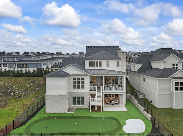 back of property with a lawn, a patio, and a balcony